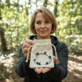 Femme tenant la pochette LORRAHA et son bracelet, en extérieur