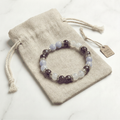 Bracelet LORRAHA posé sur sa pochette en tissu beige, sur fond blanc