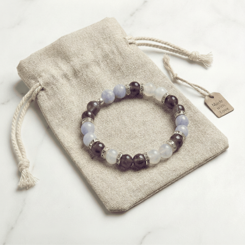 Bracelet LORRAHA posé sur sa pochette en tissu beige, sur fond blanc